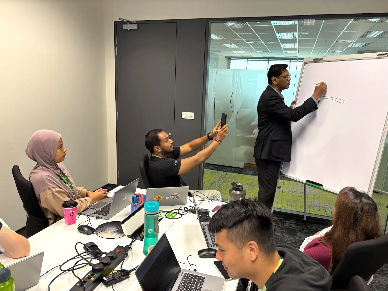 Executive presenting at a whiteboard during a Tetra training session