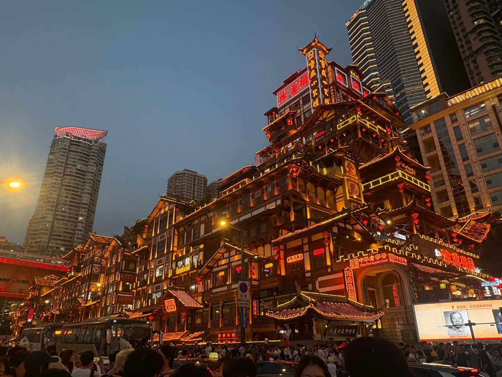 Illuminated multi-tiered traditional buildings lit up at night against a backdrop of modern skyscrapers in China